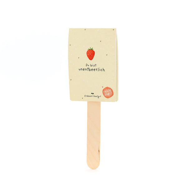 Holzstab mit einem Etikett, das eine Erdbeere und den Text âDu bist unentbeerlichâ sowie âErdbeer-Saatgutâ zeigt.