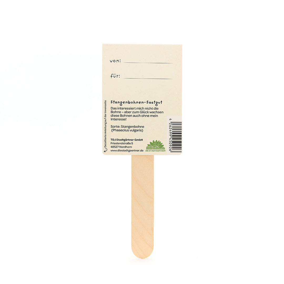 Stab mit rechteckigem Schild aus Papier, darauf Textfelder "von:" und "für:" sowie Informationen zu Stangenbohnen-Saatgut auf Deutsch.
