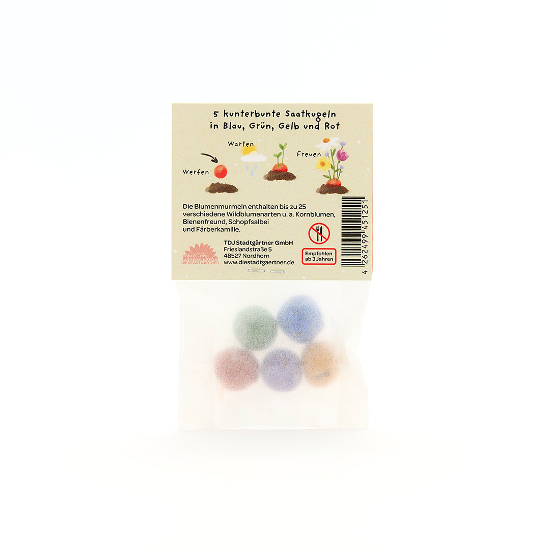 Tüte mit fünf bunten Saatkugeln in Blau, Grün, Gelb und Rot, Verpackung mit Beschreibung und Illustrationen auf Deutsch.