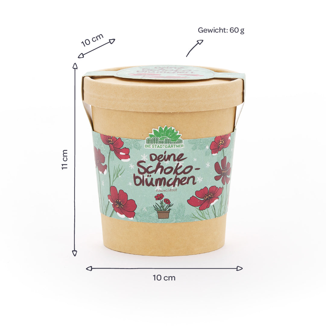 Pappbecher mit Blumenmotiv und der Aufschrift „Deine Schokoblümchen“, daneben Maße (10 cm Durchmesser, 11 cm Höhe) und Gewicht (60 g) auf Deutsch angegeben.